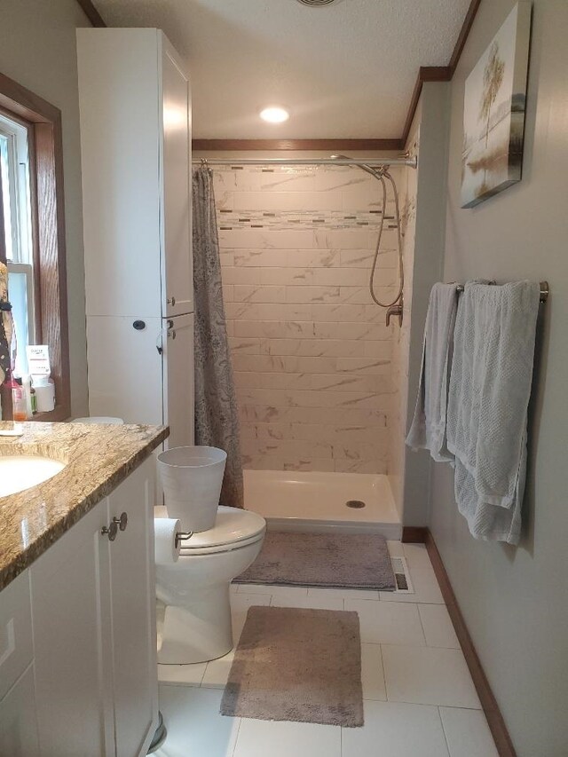 5232 E Broadway, Mount Pleasant, MI 48858 - bathroom featuring vanity, toilet, tile patterned flooring, tiled shower, and crown molding