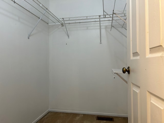 spacious closet featuring dark carpet