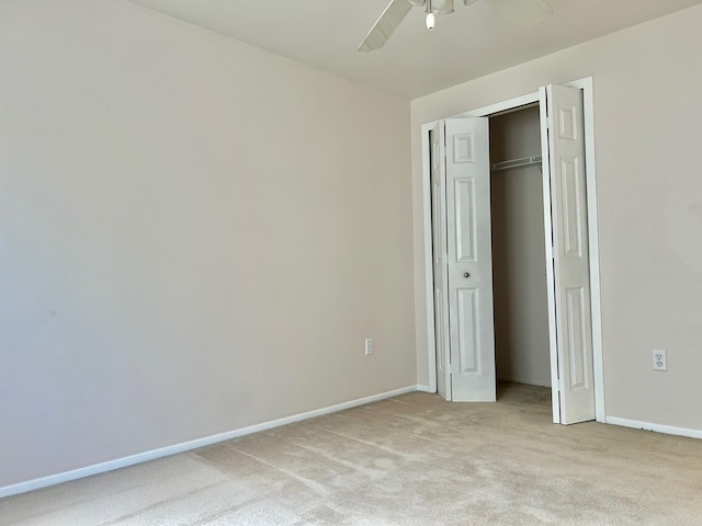 unfurnished bedroom featuring light carpet, a closet, and ceiling fan