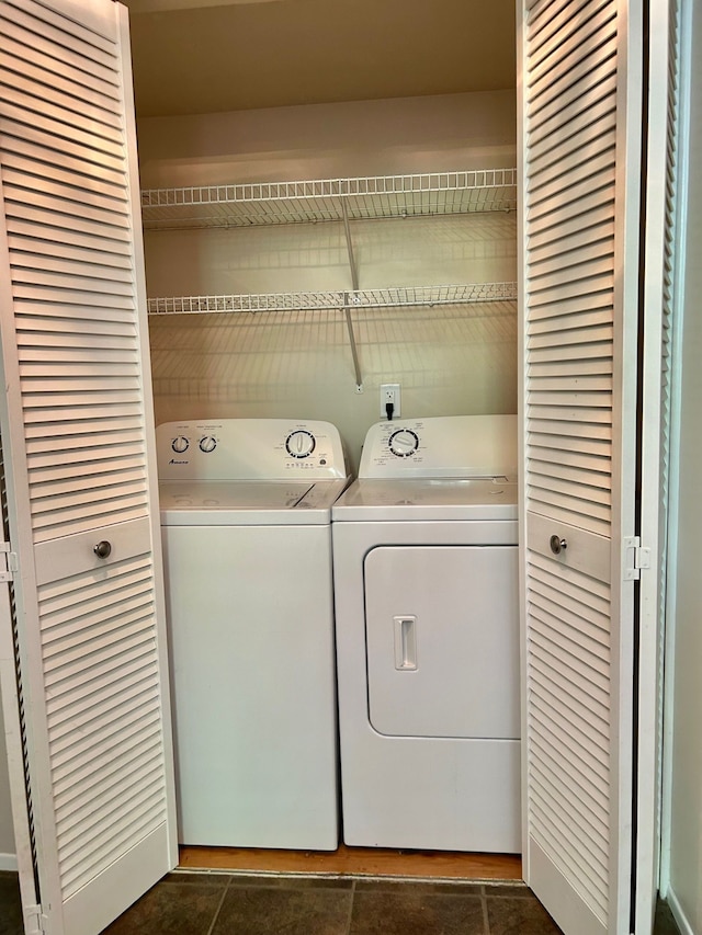 clothes washing area with separate washer and dryer and dark tile patterned floors