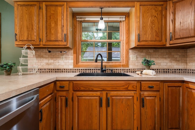 kitchen with stainless steel dishwasher, sink, backsplash, and hanging light fixtures