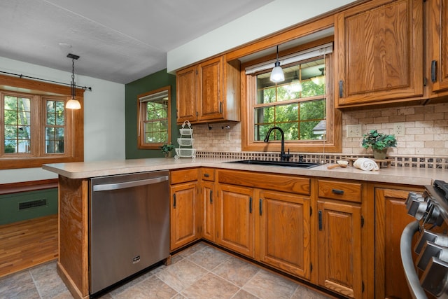 kitchen with kitchen peninsula, a healthy amount of sunlight, sink, and stainless steel appliances