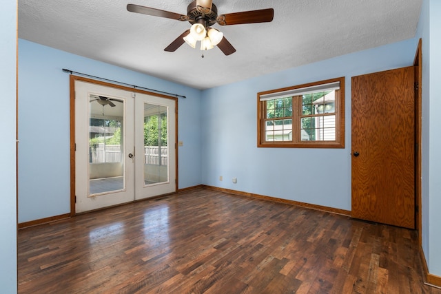 empty room with dark hardwood / wood-style floors, ceiling fan, a textured ceiling, and french doors