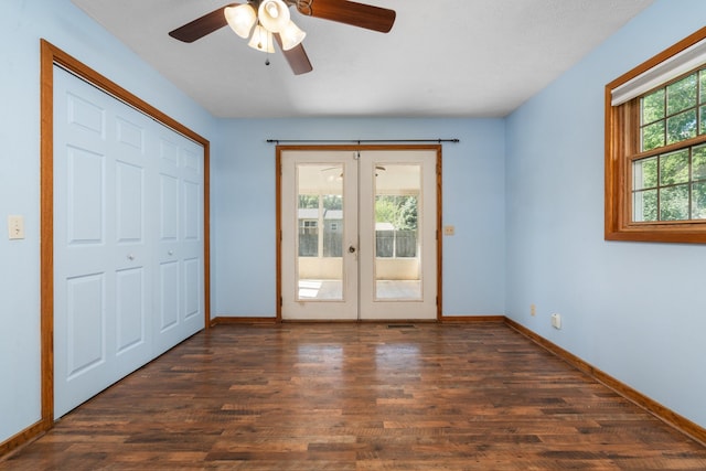 interior space featuring ceiling fan, dark wood-type flooring, a wealth of natural light, and french doors