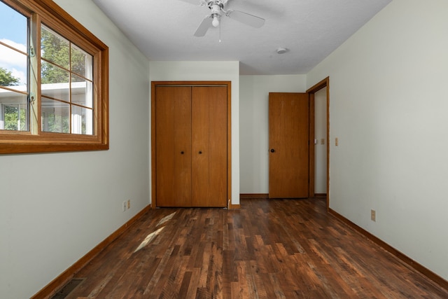 unfurnished bedroom featuring a textured ceiling, a closet, ceiling fan, and dark wood-type flooring