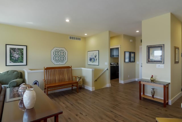 sitting room featuring washing machine and dryer and dark hardwood / wood-style flooring