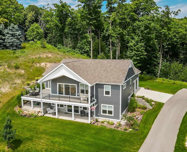 back of property featuring a lawn, a patio area, and a wooden deck