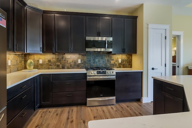 kitchen featuring backsplash, light wood-type flooring, and stainless steel appliances