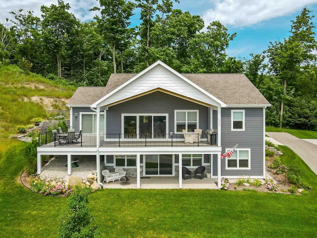 rear view of house with outdoor lounge area, a balcony, a patio area, and a lawn