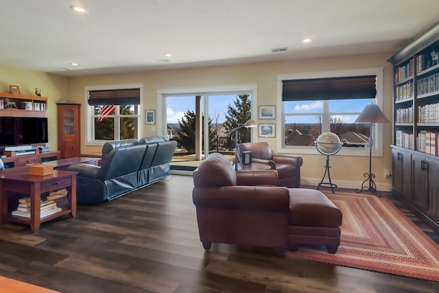 living room with dark wood-type flooring and a wealth of natural light