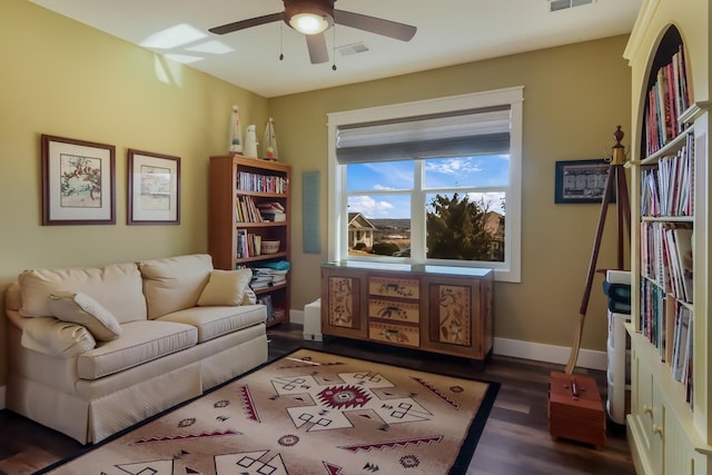 living room featuring ceiling fan and dark hardwood / wood-style flooring