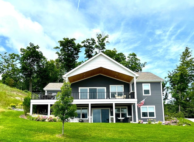 back of property with a yard and a balcony