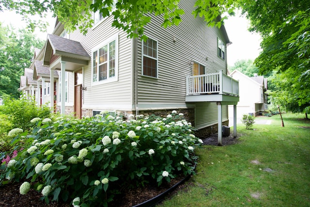 view of side of home featuring cooling unit and a yard