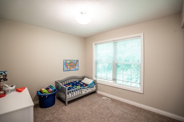 carpeted bedroom with a crib