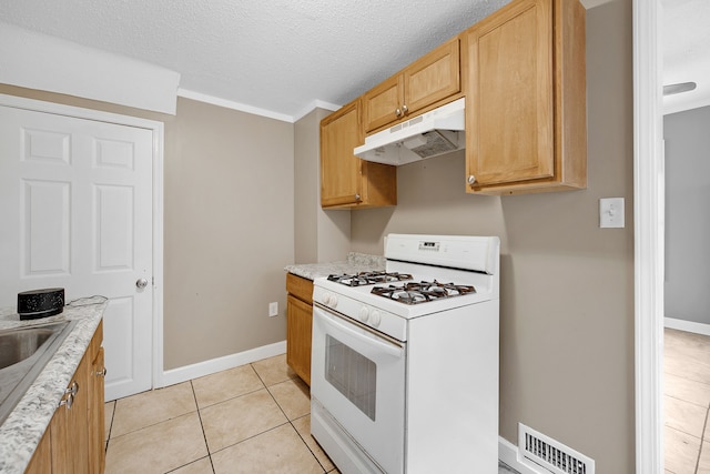 kitchen featuring light tile patterned flooring, crown molding, a textured ceiling, and white range with gas cooktop