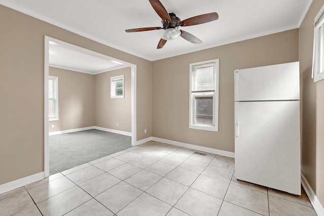 carpeted empty room with a wealth of natural light, ornamental molding, and ceiling fan