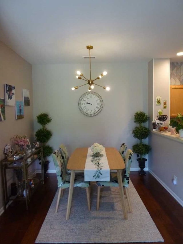 dining room featuring dark hardwood / wood-style floors and an inviting chandelier