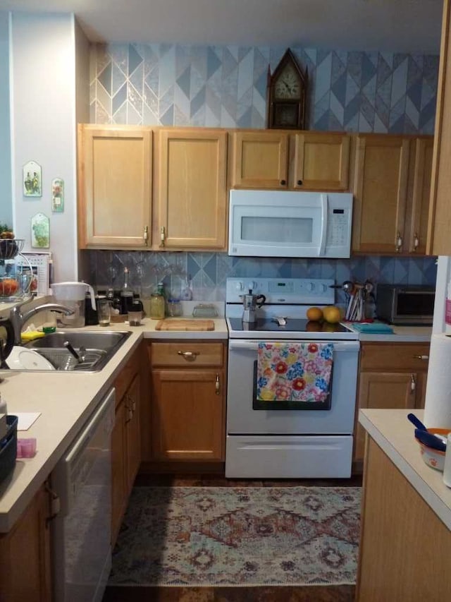 kitchen with white appliances, backsplash, and sink