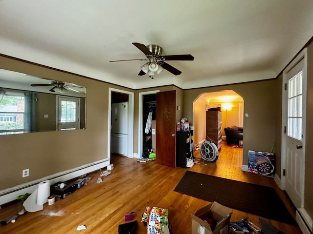 interior space featuring ceiling fan, a baseboard radiator, and hardwood / wood-style flooring