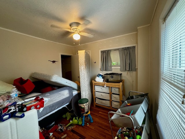 bedroom featuring ceiling fan, dark hardwood / wood-style flooring, crown molding, and a textured ceiling