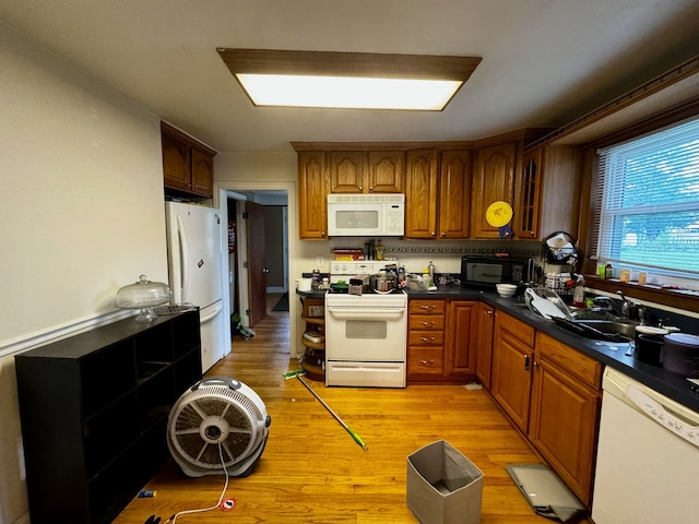 kitchen featuring white appliances, sink, and light hardwood / wood-style flooring