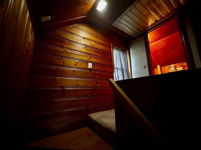 stairs with wood walls and lofted ceiling