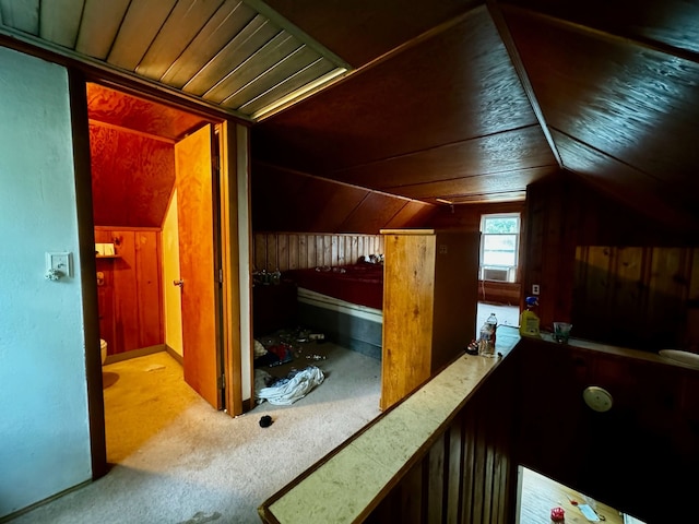 interior space with carpet flooring, wood walls, and vaulted ceiling