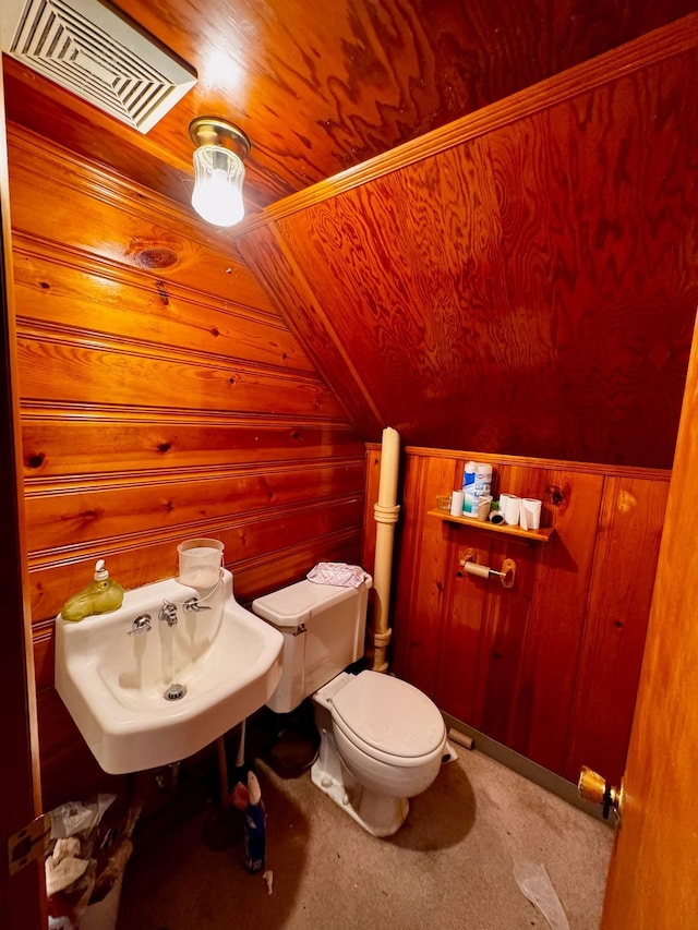 bathroom with wood walls, sink, vaulted ceiling, toilet, and wood ceiling