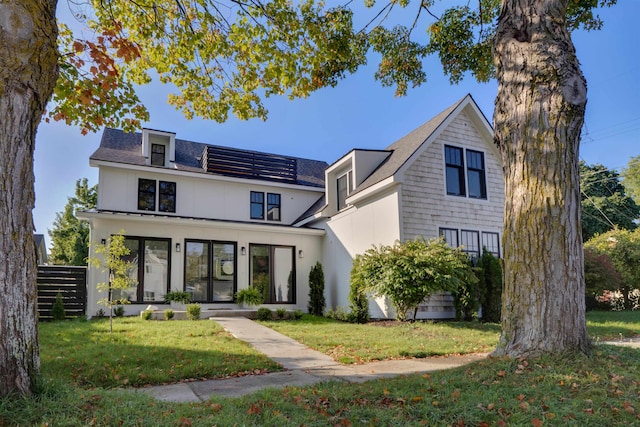 view of front facade featuring solar panels and a front lawn