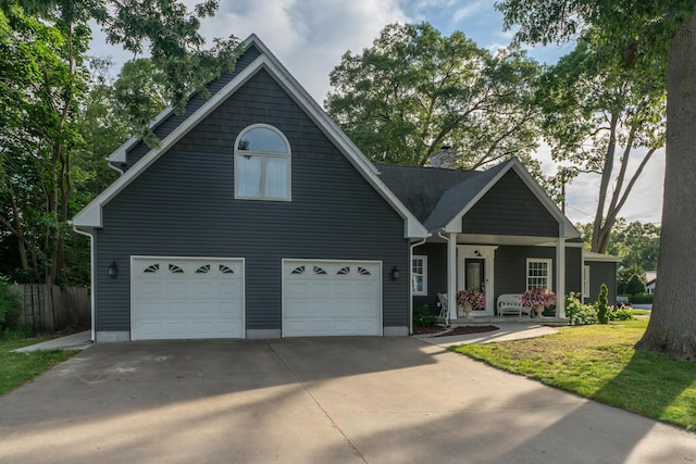 609 3rd St, Muskegon, MI 49445 - view of front of house with concrete driveway, a porch, a garage, and a chimney