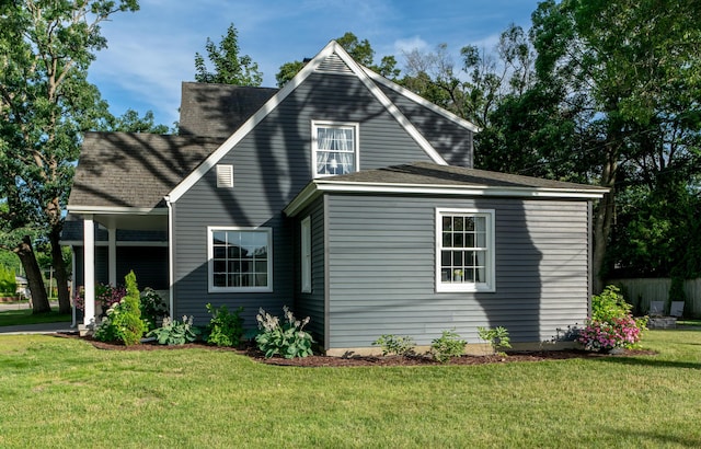 609 3rd St, Muskegon, MI 49445 - rear view of house with a lawn and roof with shingles