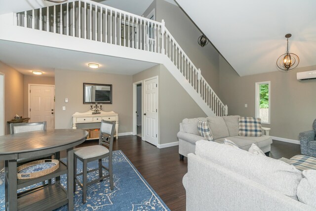 609 3rd St, Muskegon, MI 49445 - living room with an AC wall unit, dark wood-style flooring, baseboards, stairway, and a chandelier