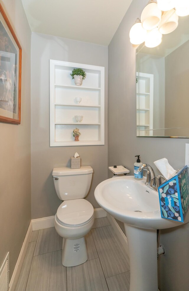 609 3rd St, Muskegon, MI 49445 - half bathroom featuring baseboards and toilet