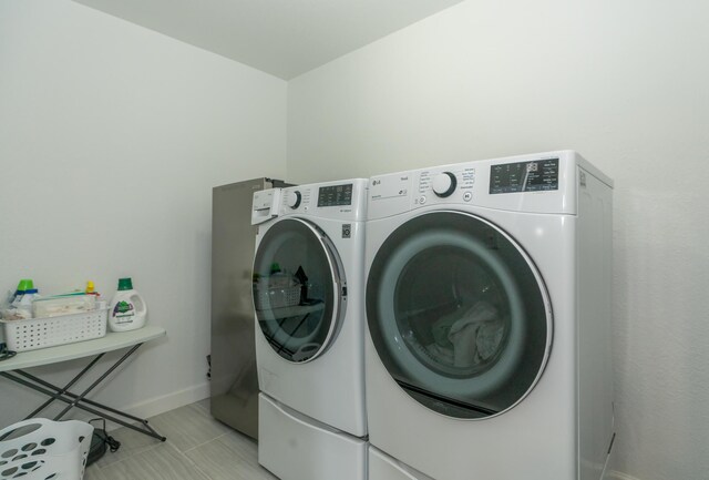 609 3rd St, Muskegon, MI 49445 - washroom with washer and dryer, baseboards, and light tile patterned flooring