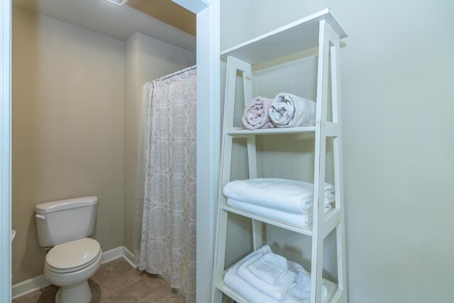 609 3rd St, Muskegon, MI 49445 - bathroom with toilet, baseboards, and a shower with curtain