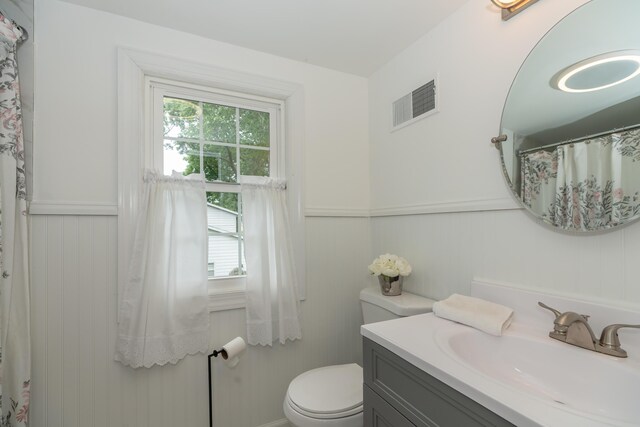 609 3rd St, Muskegon, MI 49445 - full bathroom with vanity, toilet, a wainscoted wall, and a decorative wall