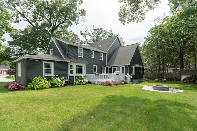 609 3rd St, Muskegon, MI 49445 - back of property featuring an outdoor fire pit, a deck, a chimney, a yard, and a shingled roof