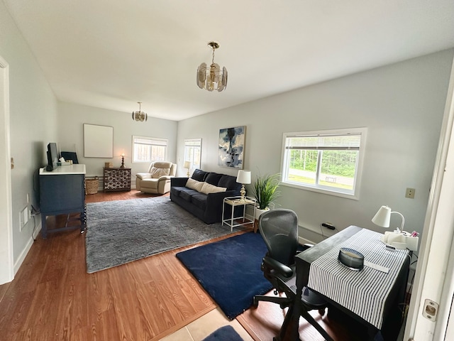 office space with hardwood / wood-style floors, a healthy amount of sunlight, and an inviting chandelier