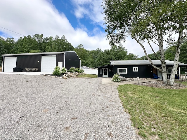 view of front of home with a front yard, an outbuilding, and a garage