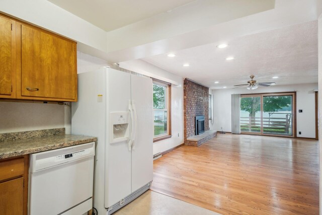 2973 Round Lake Hwy, Manitou Beach, MI 49253 - kitchen featuring white appliances, a fireplace, recessed lighting, brown cabinetry, and light wood-type flooring