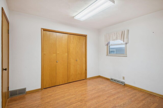 2973 Round Lake Hwy, Manitou Beach, MI 49253 - unfurnished bedroom featuring light wood-style floors, baseboards, and a closet