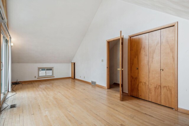 additional living space with lofted ceiling and light wood-type flooring