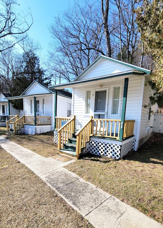 view of front of home with covered porch and a front yard