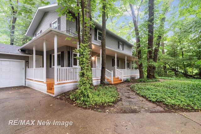 country-style home featuring a porch and a garage