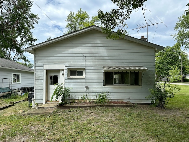 rear view of property featuring a yard