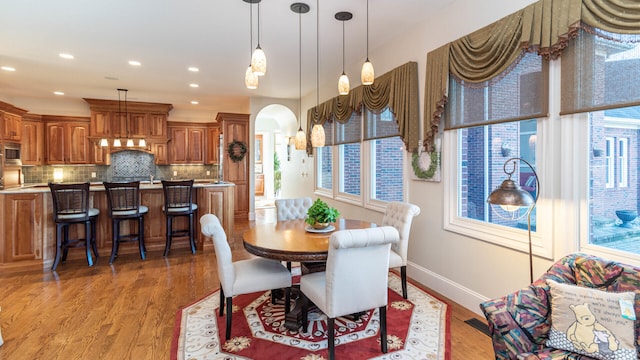 740 Greystone Dr, Chelsea, MI 48118 - dining space featuring arched walkways, light wood-style floors, baseboards, and recessed lighting