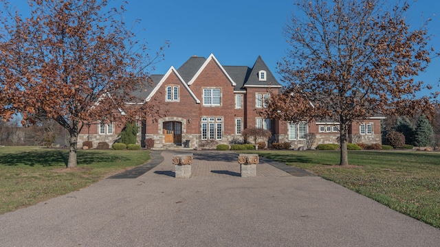740 Greystone Dr, Chelsea, MI 48118 - georgian-style home with stone siding, a front lawn, and brick siding
