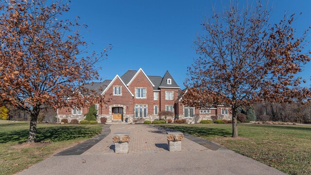 740 Greystone Dr, Chelsea, MI 48118 - colonial inspired home featuring stone siding, a front lawn, and brick siding