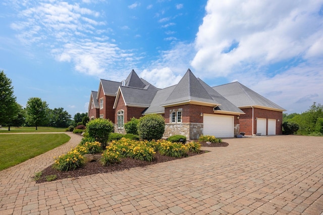 740 Greystone Dr, Chelsea, MI 48118 - view of home's exterior with an attached garage, brick siding, decorative driveway, and a yard
