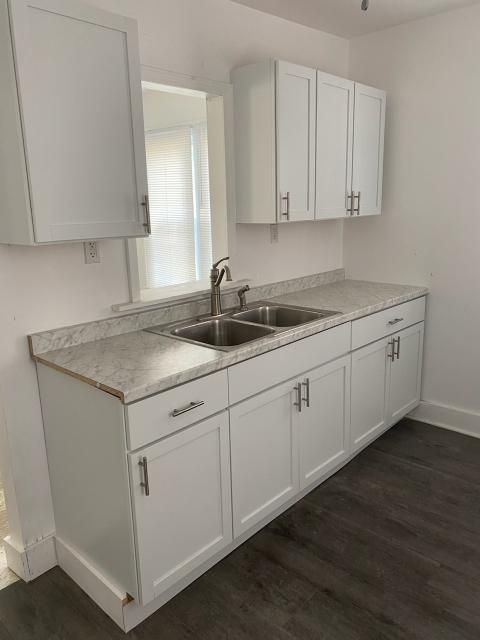 kitchen featuring white cabinetry, dark wood-type flooring, and sink